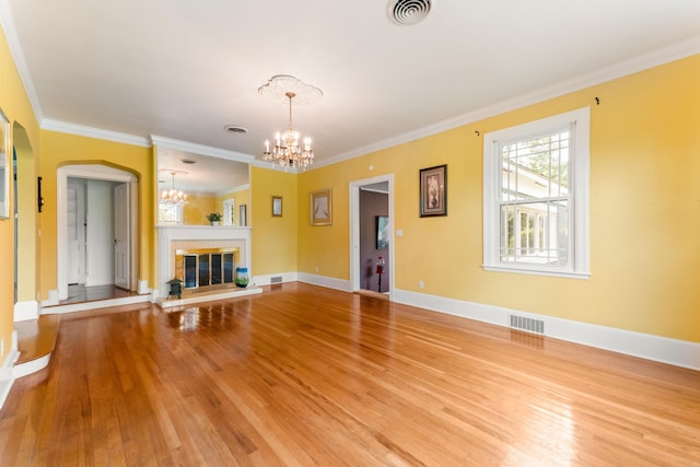 unfurnished living room with an inviting chandelier, light wood-style flooring, and visible vents