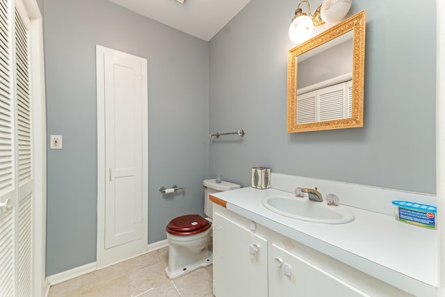 bathroom with tile patterned floors, a closet, toilet, vanity, and baseboards
