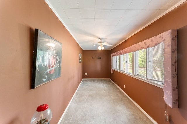 hall featuring carpet floors, crown molding, and baseboards