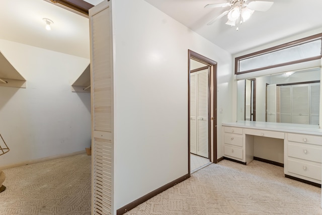 bathroom with a ceiling fan, vanity, and baseboards