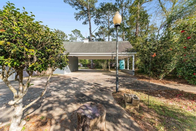 view of front of home with driveway, an attached carport, and stucco siding