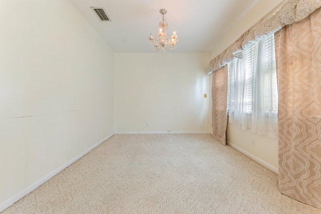 empty room with carpet floors, baseboards, a chandelier, and visible vents