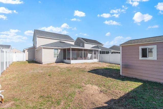 back of house featuring a yard and a sunroom