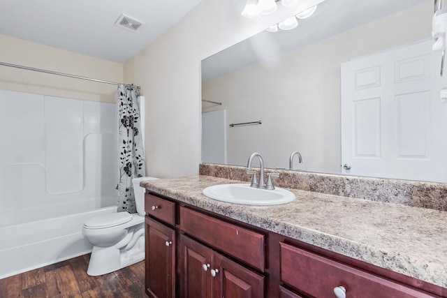 full bathroom featuring vanity, hardwood / wood-style floors, shower / bath combination with curtain, and toilet