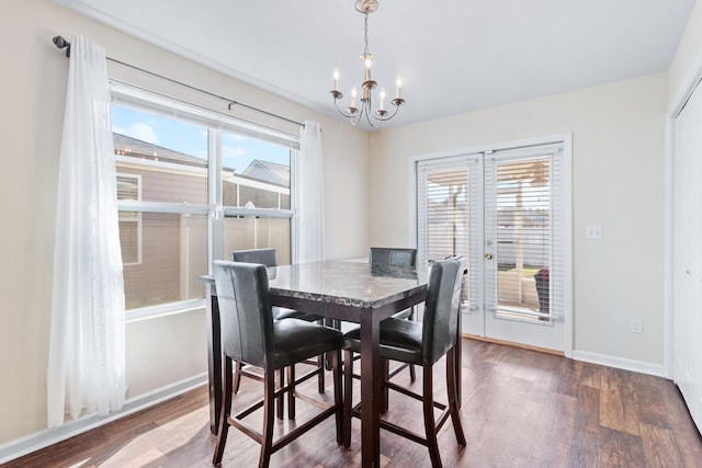 dining room with wood-type flooring, plenty of natural light, and a notable chandelier