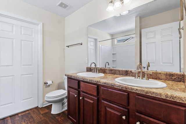 bathroom with vanity, wood-type flooring, a shower, and toilet