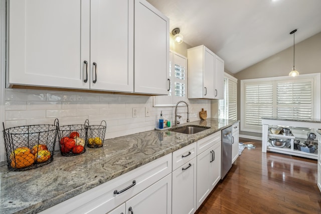 kitchen featuring dark wood-type flooring, a sink, stainless steel dishwasher, white cabinetry, and vaulted ceiling