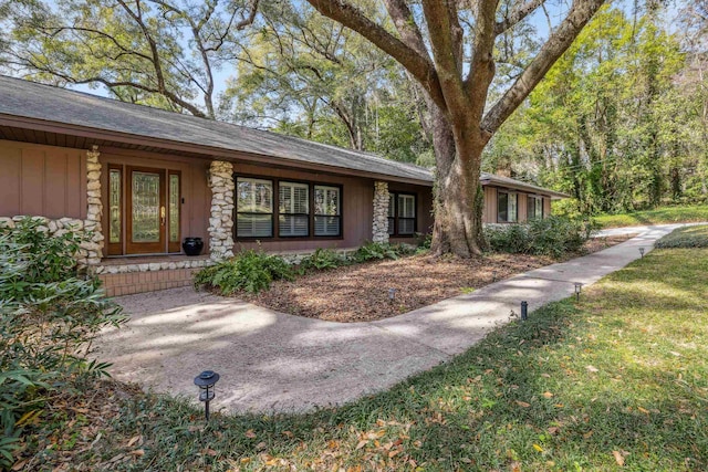 view of front of property with stone siding and a front yard
