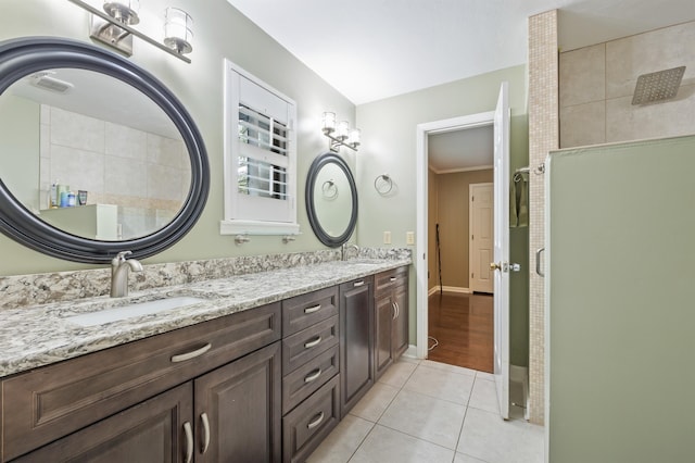 full bathroom featuring tile patterned flooring, double vanity, baseboards, and a sink