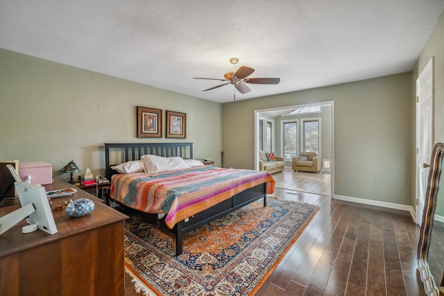 bedroom featuring baseboards, dark wood-style floors, and a ceiling fan