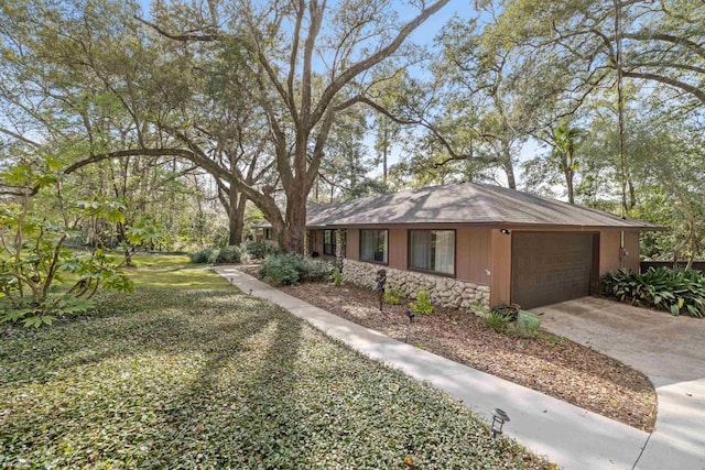 view of front of property featuring concrete driveway, an attached garage, and stone siding