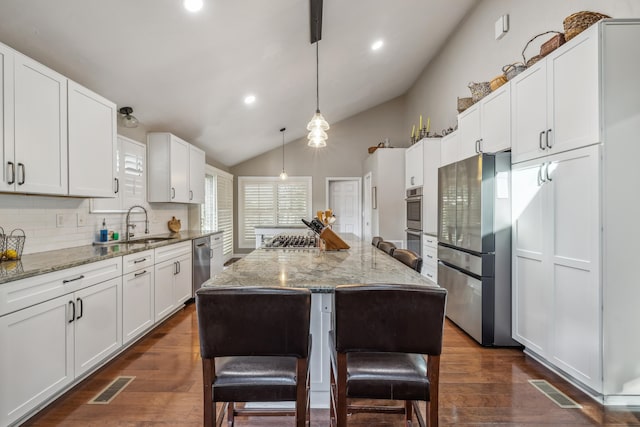 kitchen featuring dark wood finished floors, visible vents, appliances with stainless steel finishes, and a sink