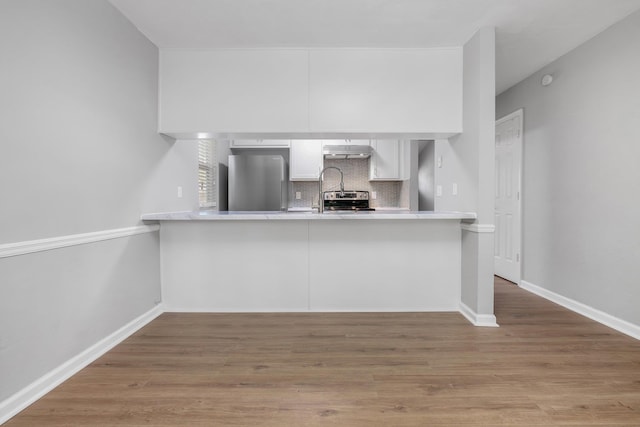 3146 Oak Hammock Ln, Tallahassee, FL 32301 - kitchen featuring stainless steel appliances, under cabinet range hood, a peninsula, white cabinets, and light countertops