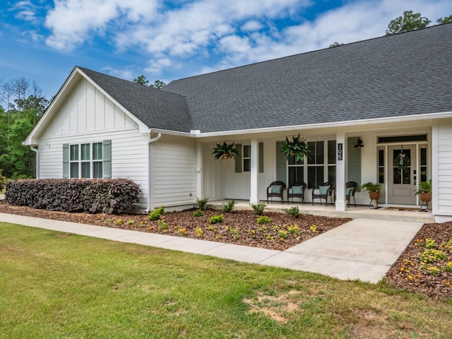 195 Coe Landing Rd, Tallahassee, FL 32310 - view of front of property featuring a shingled roof, a porch, board and batten siding, and a front lawn