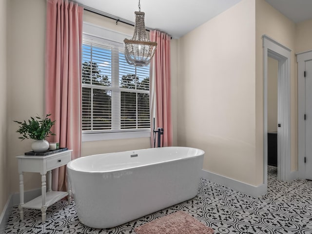 195 Coe Landing Rd, Tallahassee, FL 32310 - bathroom featuring a soaking tub, baseboards, and a notable chandelier