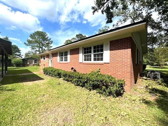 view of side of home with a lawn