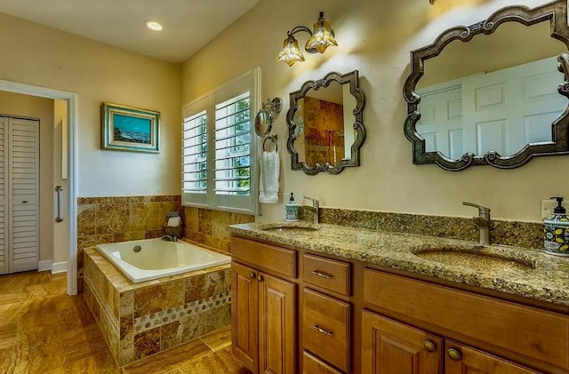 bathroom featuring vanity and tiled bath