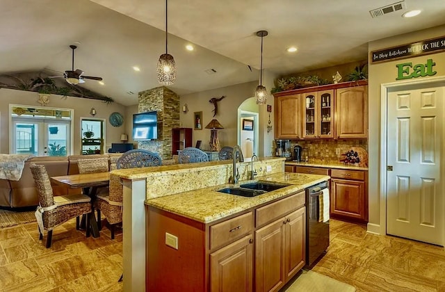 kitchen featuring pendant lighting, sink, dishwasher, a kitchen island with sink, and french doors