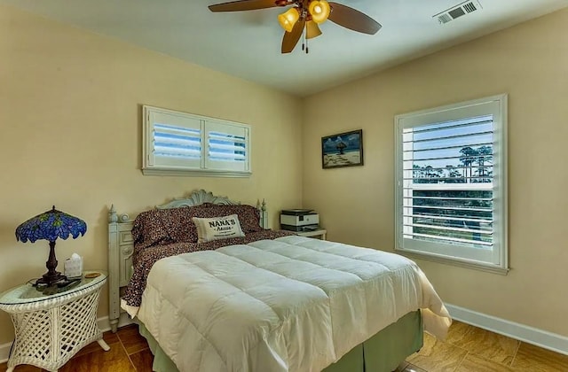 bedroom with ceiling fan and multiple windows