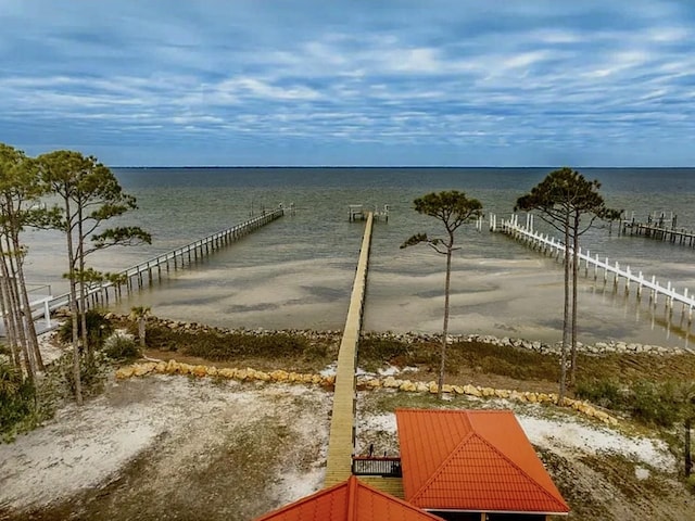 dock area with a water view and a beach view