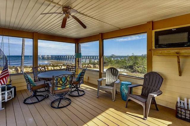 sunroom featuring a water view and ceiling fan