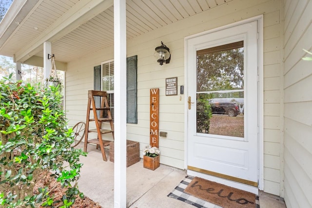 view of exterior entry featuring covered porch