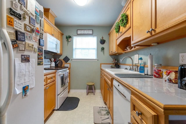 kitchen featuring sink, white appliances, and tile counters