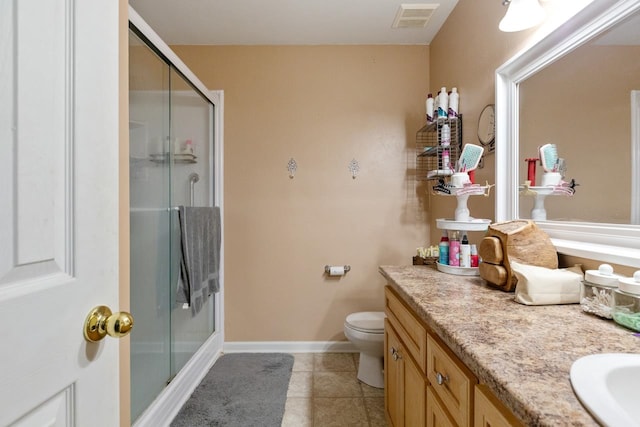 bathroom with toilet, vanity, tile patterned flooring, and a shower with shower door