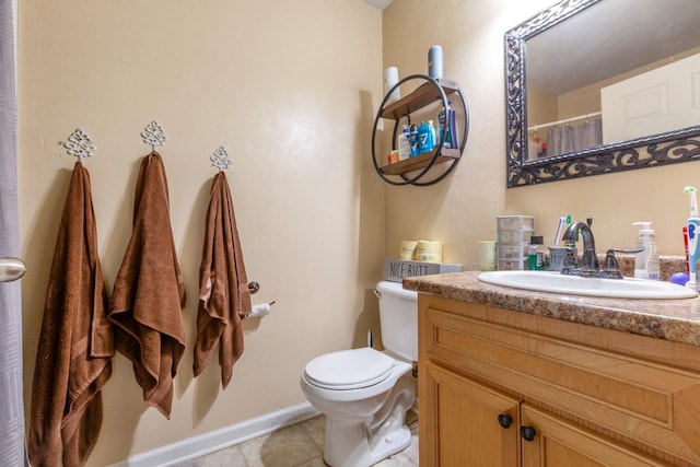 bathroom with toilet, vanity, and tile patterned flooring