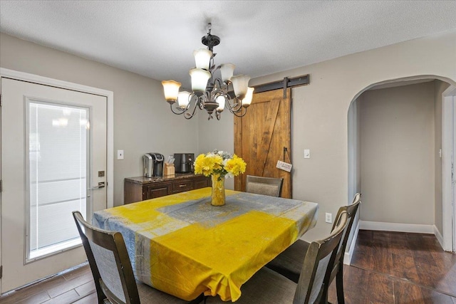 127 E Nancy St, Perry, FL 32347 - dining area featuring arched walkways, an inviting chandelier, wood finished floors, and baseboards