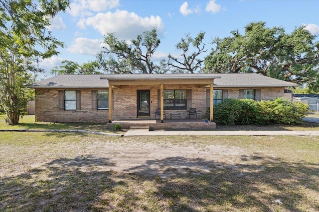 127 E Nancy St, Perry, FL 32347 - ranch-style house with covered porch, brick siding, and a front yard