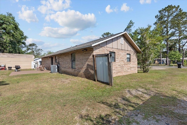 127 E Nancy St, Perry, FL 32347 - rear view of house with a patio, a yard, board and batten siding, and brick siding