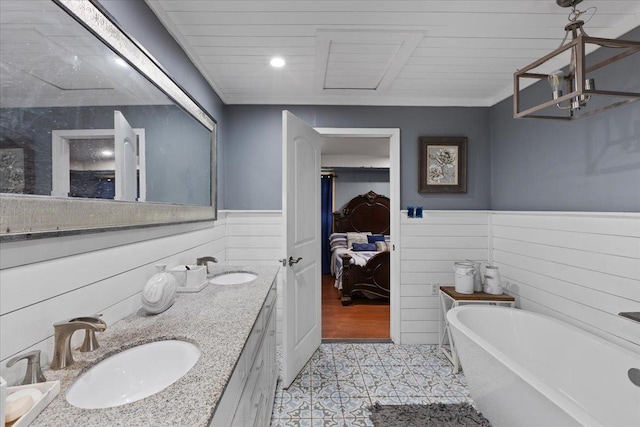 127 E Nancy St, Perry, FL 32347 - ensuite bathroom with a sink, a wainscoted wall, tile patterned flooring, a soaking tub, and ensuite bathroom