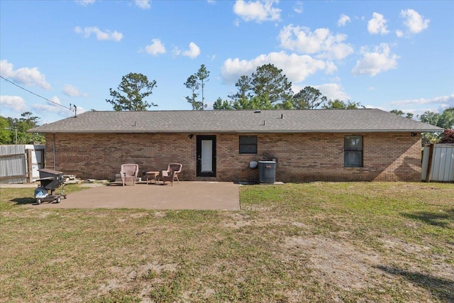 127 E Nancy St, Perry, FL 32347 - rear view of house with a patio, brick siding, central AC unit, and a lawn