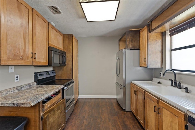 127 E Nancy St, Perry, FL 32347 - kitchen with a sink, appliances with stainless steel finishes, visible vents, baseboards, and dark wood-style flooring