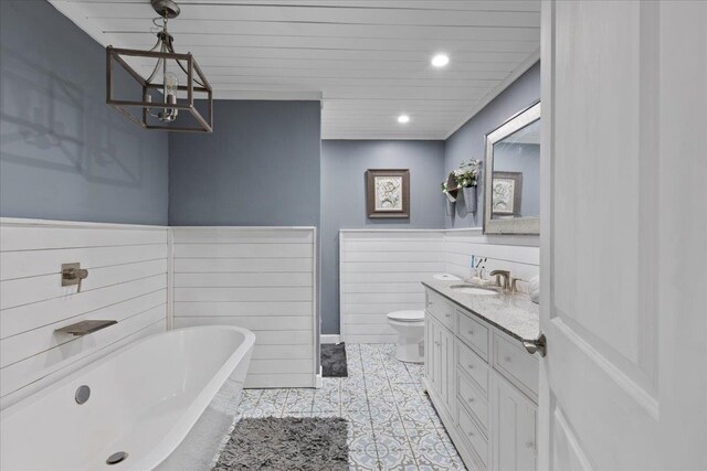 127 E Nancy St, Perry, FL 32347 - bathroom with tile patterned flooring, a freestanding bath, toilet, vanity, and a notable chandelier