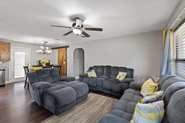 127 E Nancy St, Perry, FL 32347 - living room featuring a textured ceiling, a barn door, baseboards, dark wood-type flooring, and ceiling fan with notable chandelier