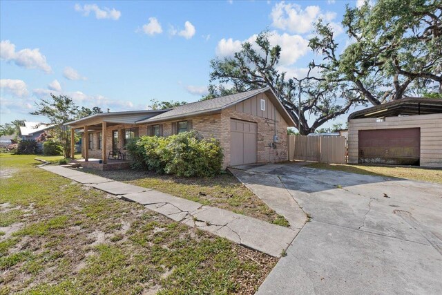 127 E Nancy St, Perry, FL 32347 - view of front of property featuring driveway, a front yard, fence, a porch, and brick siding