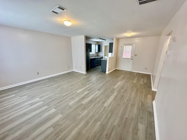 3180 N Ridge Rd -, Unit Tallahassee, FL 32305 - unfurnished living room featuring visible vents, baseboards, and light wood-type flooring