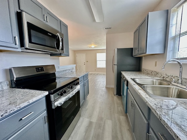 3180 N Ridge Rd -, Unit Tallahassee, FL 32305 - kitchen featuring visible vents, appliances with stainless steel finishes, light wood-type flooring, a sink, and gray cabinetry