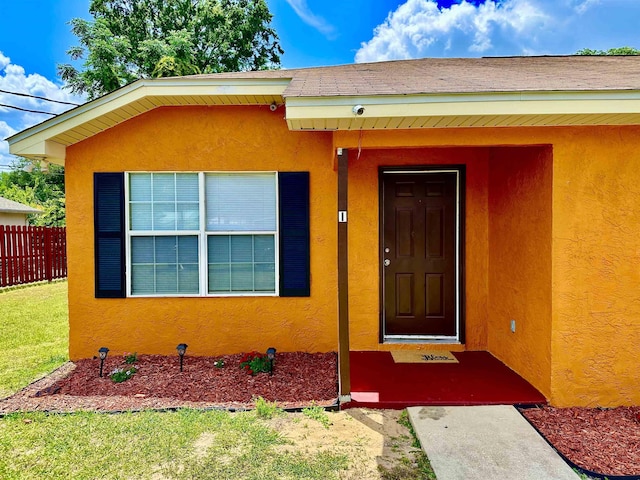 3180 N Ridge Rd -, Unit Tallahassee, FL 32305 - view of exterior entry with stucco siding, a yard, and fence