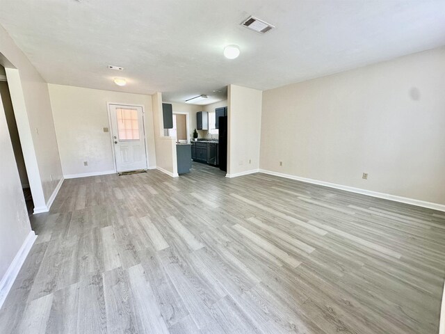 3180 N Ridge Rd -, Unit Tallahassee, FL 32305 - unfurnished living room with baseboards, light wood-type flooring, and visible vents