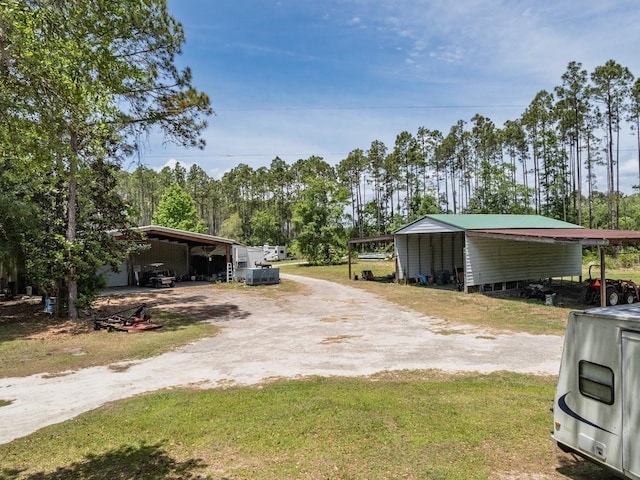 881 Hickory Hammock Rd, Carrabelle, FL 32322 - view of green lawn featuring dirt driveway, a carport, and view of scattered trees
