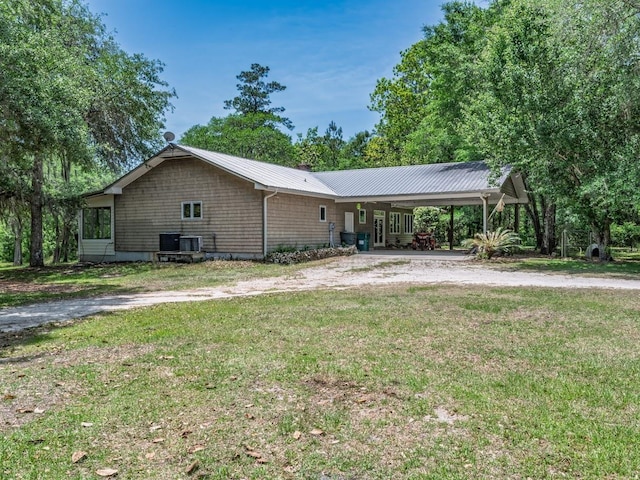 881 Hickory Hammock Rd, Carrabelle, FL 32322 - view of property exterior featuring a lawn, an attached carport, metal roof, driveway, and central AC unit