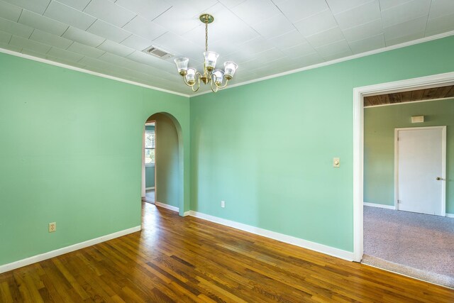 253 Prado St, Apalachicola, FL 32320 - spare room featuring arched walkways, crown molding, a chandelier, wood finished floors, and baseboards