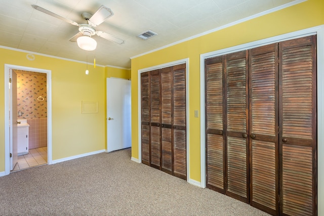 253 Prado St, Apalachicola, FL 32320 - unfurnished bedroom with two closets, carpet flooring, crown molding, baseboards, and a ceiling fan