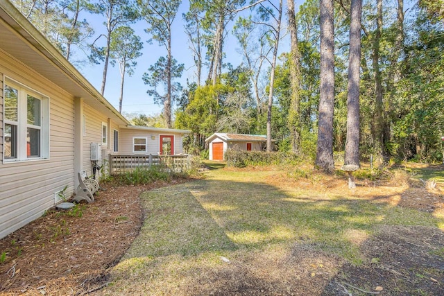 253 Prado St, Apalachicola, FL 32320 - view of green lawn featuring an outbuilding, a deck, and a shed