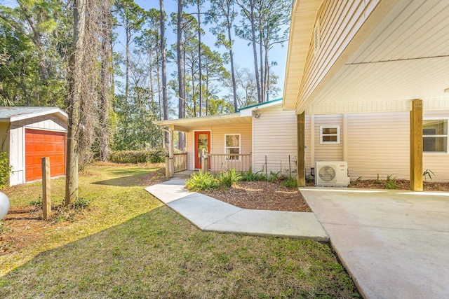 253 Prado St, Apalachicola, FL 32320 - view of green lawn featuring covered porch, a cooling unit, and an outdoor structure