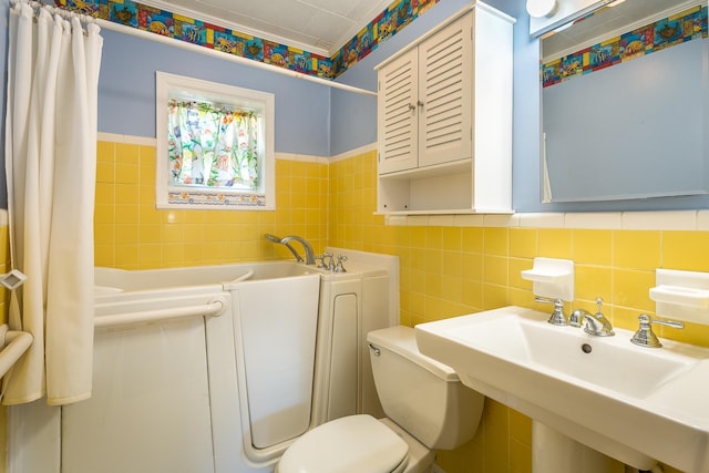 253 Prado St, Apalachicola, FL 32320 - full bath featuring tile walls, toilet, a tub to relax in, a sink, and a wainscoted wall