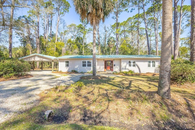 253 Prado St, Apalachicola, FL 32320 - ranch-style house featuring driveway, metal roof, a carport, and view of scattered trees